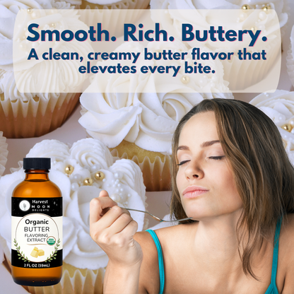 Woman tasting a cupcake with a bottle of organic butter flavoring extract in front of cupcakes.